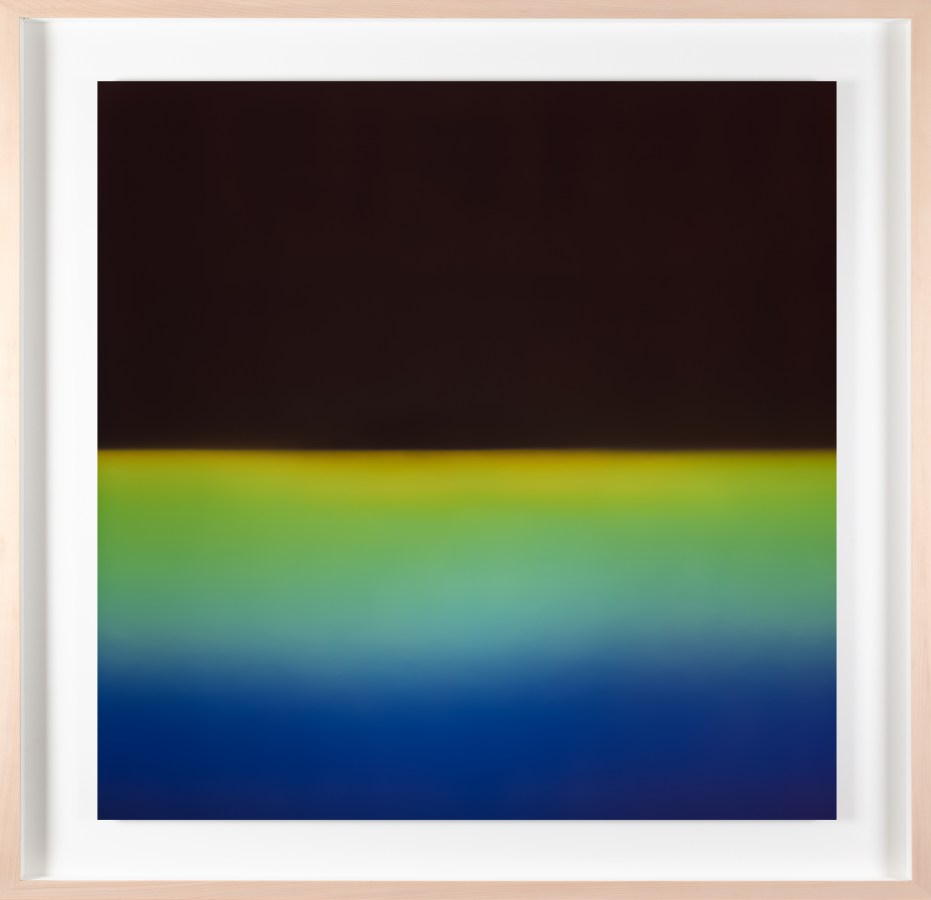 Framed color photograph of a gradient of blue, green, and yellow light