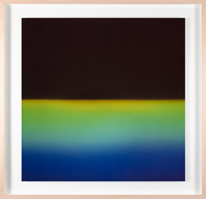 Framed color photograph of a gradient of blue, green, and yellow light