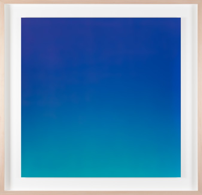 Color photograph of a blue hued gradient framed in a bleached wood frame