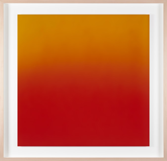Color photograph of a yellow and red gradient framed in a light pine