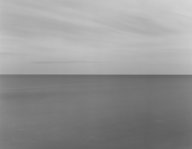 Black and white photograph of the horizon with equal parts sky and sea