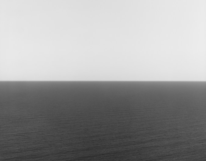 Black and white photograph of the horizon with equal parts sky and sea