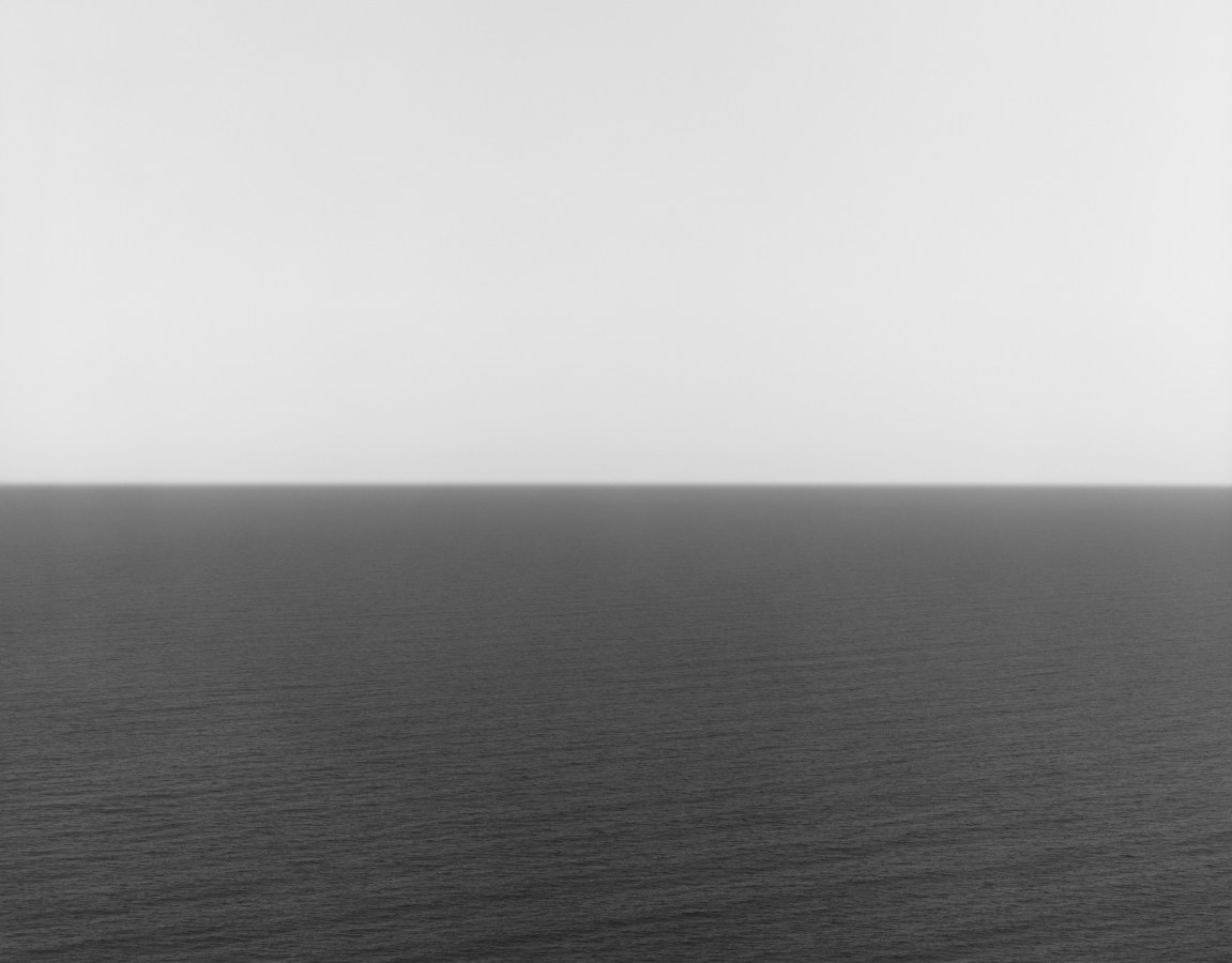 Black and white photograph of the horizon with equal parts sky and sea