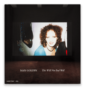 Color image of a book cover depicting a screen projecting images of documentation and self portraiture